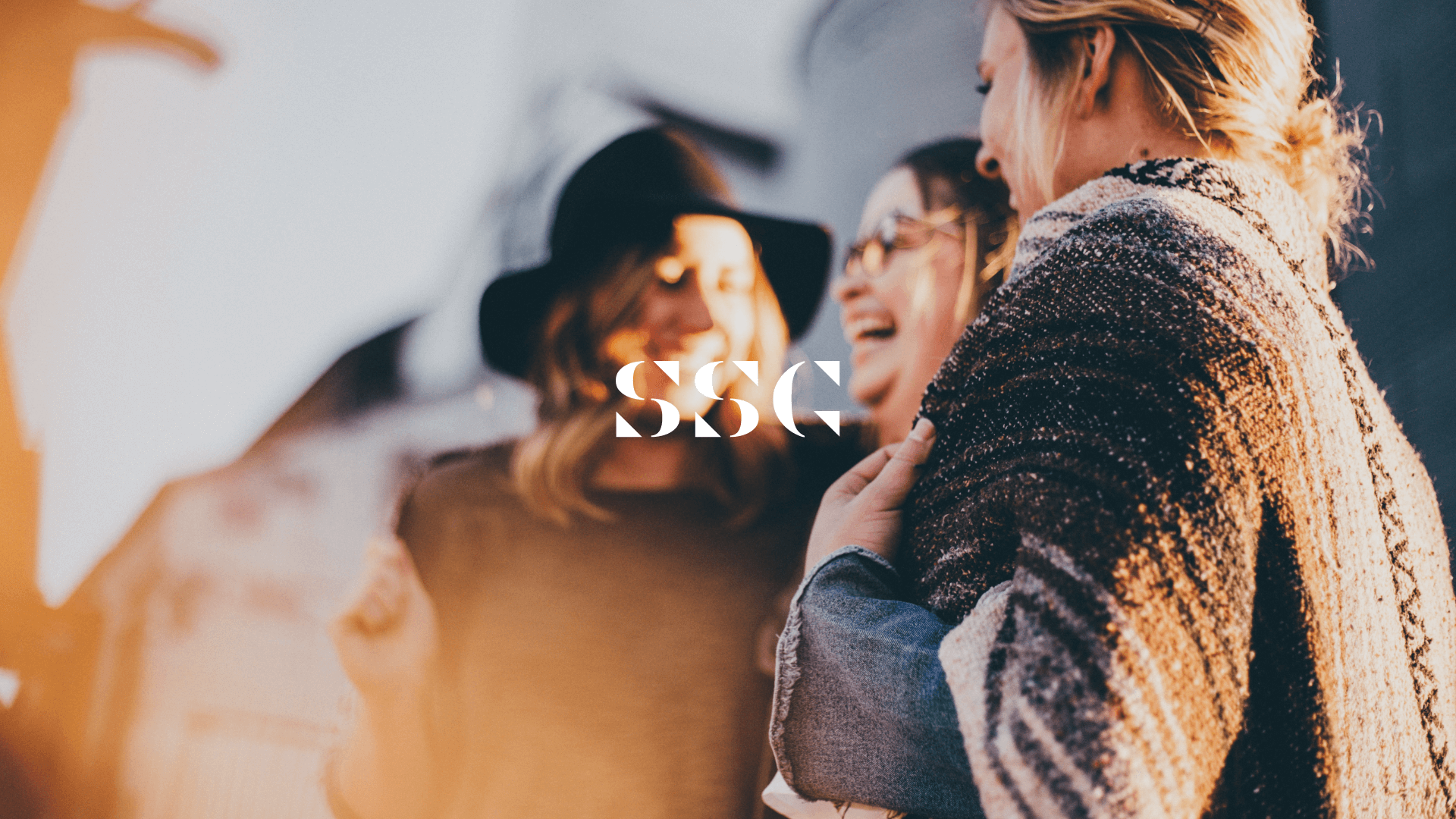 SSG Logo in white on top of a group of people talking